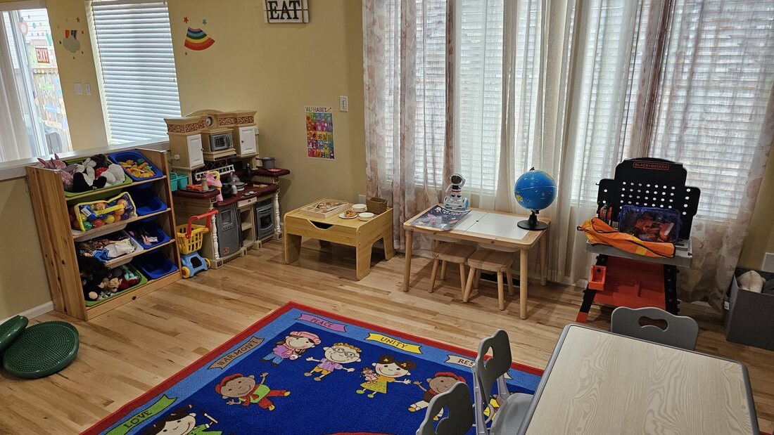 Pretend kitchen and discovery table beside the windows